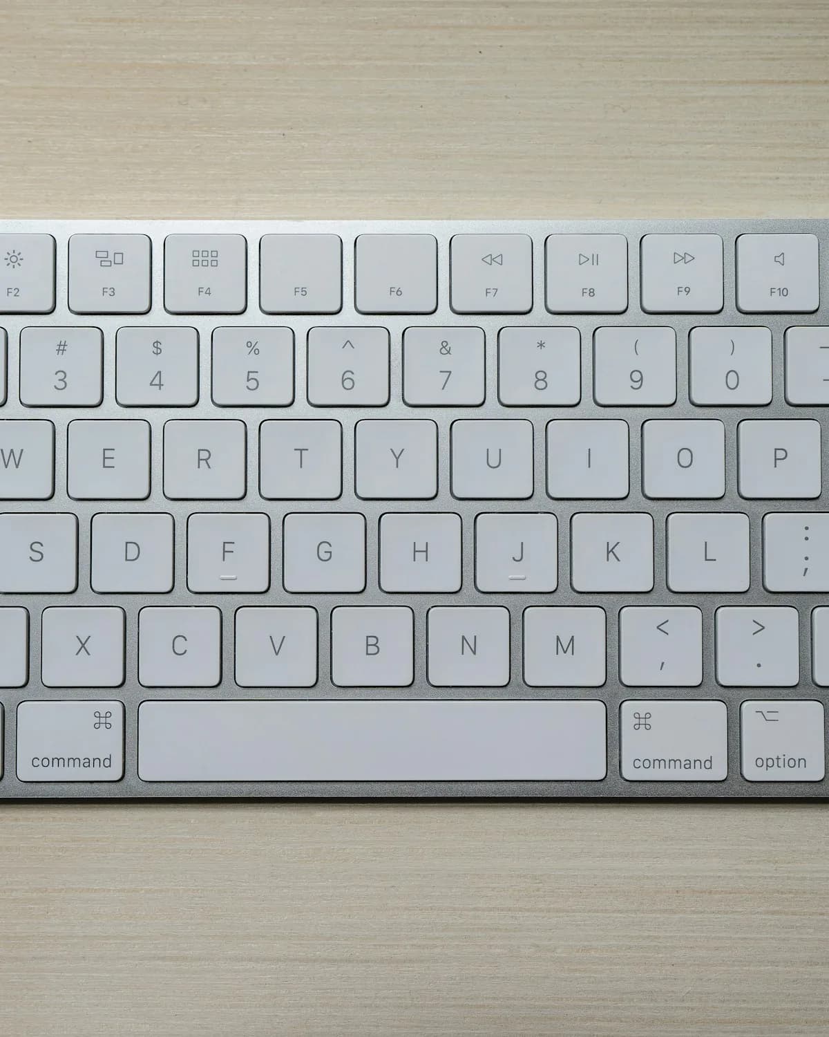 Slate low-profile keyboard in chalk on a light oak desk