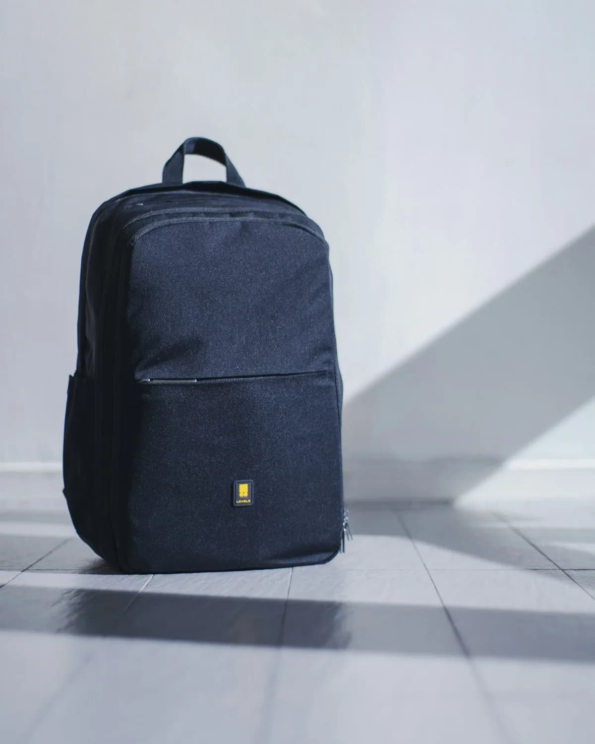 Transit Daypack in navy standing on a concrete floor