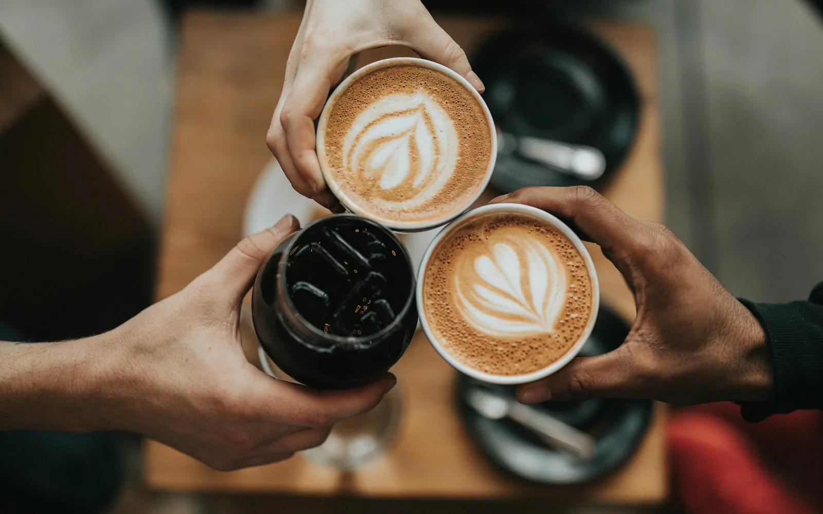 Three cups of coffee being shared over a table